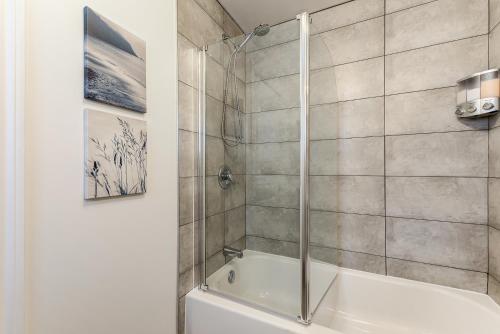 a bathroom with a shower and a white tub at Le Royale - Havre de paix in Quebec City