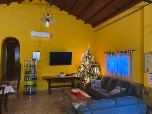 un salon avec un canapé bleu et un arbre de Noël dans l'établissement I Gelsomini, à Marinella di Selinunte