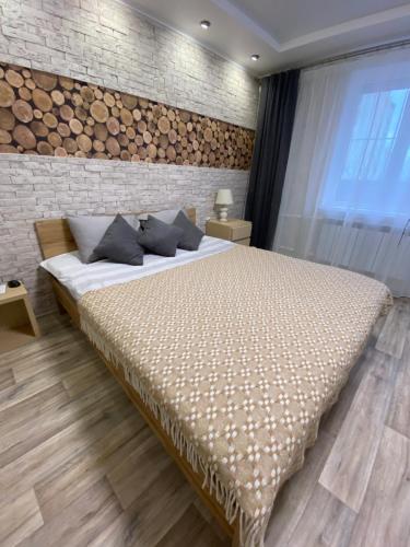 a bedroom with a large bed and a brick wall at Larionov Great Apartment (1 room) in Tiraspol