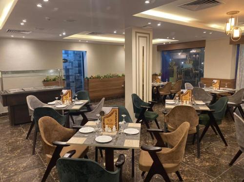 um restaurante com mesas e cadeiras e um bar em Jewel Agouza Hotel no Cairo