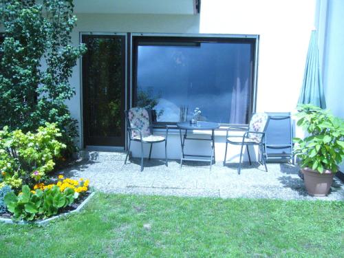 a patio with a table and chairs in a yard at Ferienwohnung Erika in Grenzach-Wyhlen
