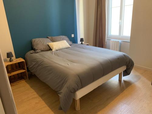 Bett in einem Schlafzimmer mit blauer Wand in der Unterkunft Un Toit Pour Vous in Les Épesses