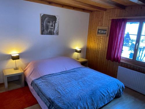 ein Schlafzimmer mit einem Bett, zwei Lampen und einem Fenster in der Unterkunft California House in Klosters