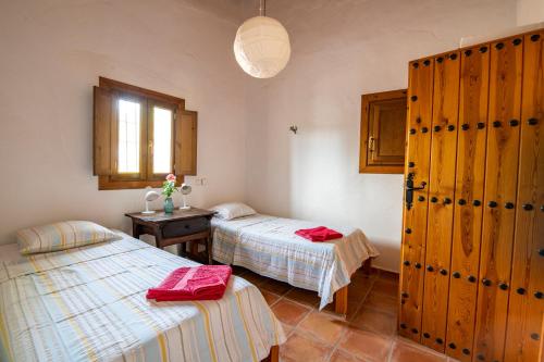 een slaapkamer met 2 bedden, een tafel en een raam bij Casa Chica in Pizarra