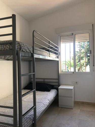 a room with two bunk beds and a window at VILLA JAZMÍN in Monachil