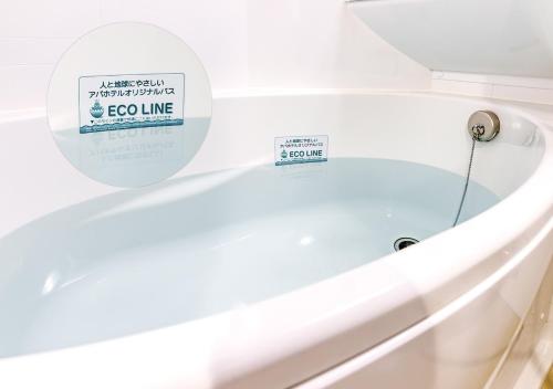 a white bath tub with a sign on it at APA Hotel Nishifunabashi Ekimae in Funabashi