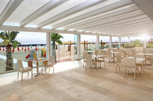 a restaurant with tables and chairs and a view of the ocean at Baldinini Hotel in Rimini
