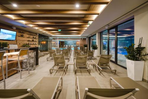 a restaurant with chairs and tables and windows at Gorski Hotel & Spa in Kopaonik