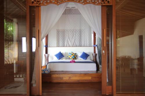 1 dormitorio con 1 cama con dosel en Bali Marina Villa's en Amed