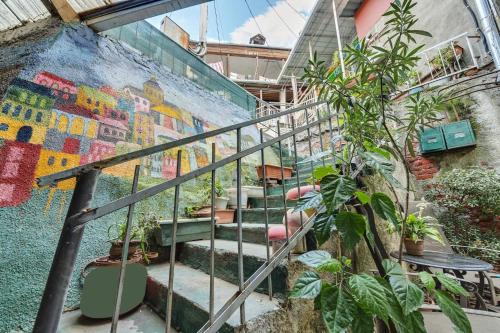 a set of stairs with plants and a mural at House 52 Boutique Hotel in Tbilisi City