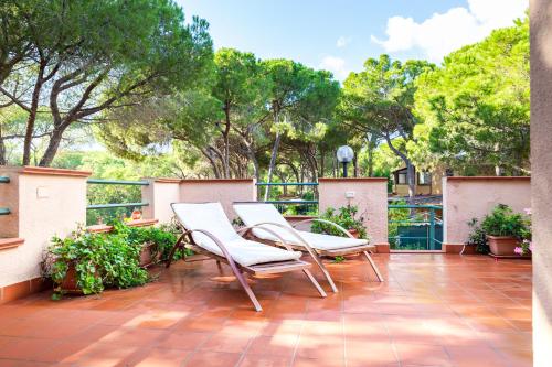 two chairs and a table on a patio at bilocale Pinewood in Santa Margherita di Pula