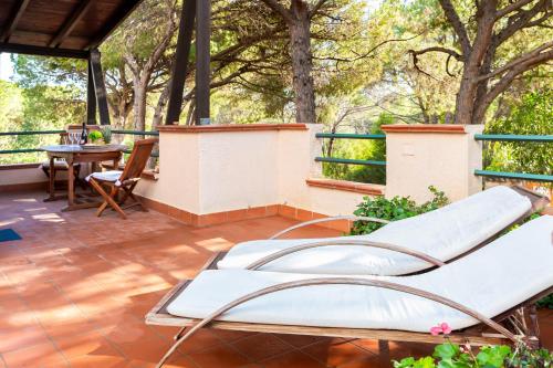 a patio with a bed and a table and chairs at bilocale Pinewood in Santa Margherita di Pula