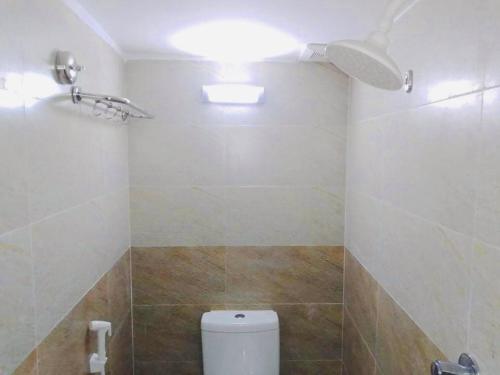 a bathroom with a toilet and a ceiling fan at Hotel Seven Star in Dhaka