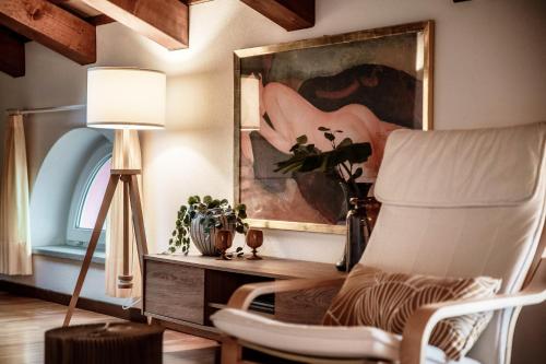 a living room with a chair and a painting at Salorino Apartments by Quokka 360 - with a view of nature in Mendrisio