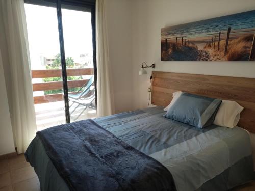 a bedroom with a bed and a large window at APARTMENT LA CALA DESIGN & ALAMAR SEA WIEW. in La Cala de Mijas