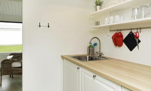 a kitchen with a sink and a counter top at Cozy Coastal Retreat on the beach in Brenderup
