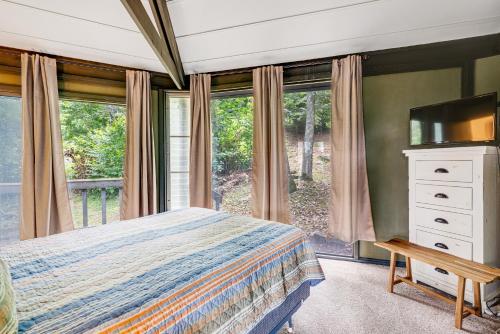 a bedroom with a bed and a tv and windows at Slopesider 01 in Sugar Mountain