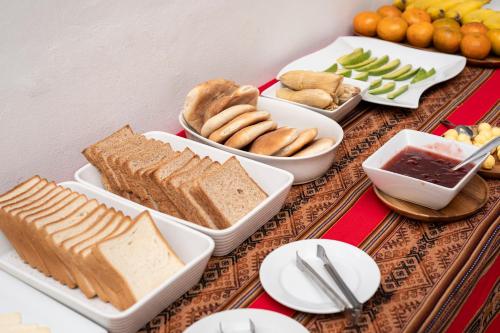 a table topped with different types of bread and other foods at Hotel Cusco Plaza Saphi in Cusco
