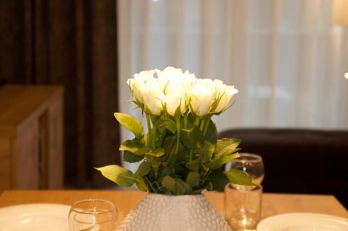 a vase filled with white flowers on a table at Residenz Grafenmatt Feldberg in Feldberg