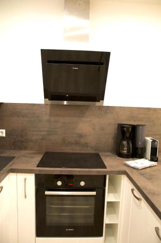 a kitchen with a black stove and a microwave at Residenz Grafenmatt Feldberg in Feldberg