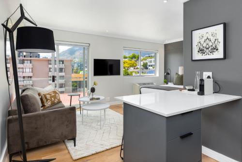 a kitchen and living room with a couch and a table at Point Break Luxury Apartments in Cape Town