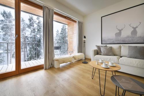 a living room with a couch and a table at Element Lakeside Apartments in Lipno nad Vltavou