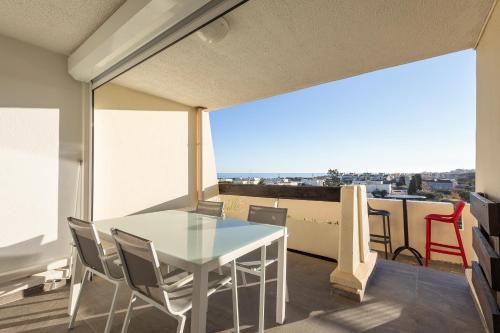une salle à manger avec une table et des chaises sur un balcon dans l'établissement Crazy dream Naturiste, au Cap d'Agde