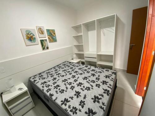 a small bedroom with a black and white bed at PALMEIRAS A14 in Ubatuba