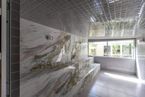 a bathroom with a large marble wall at PALMEIRAS A14 in Ubatuba