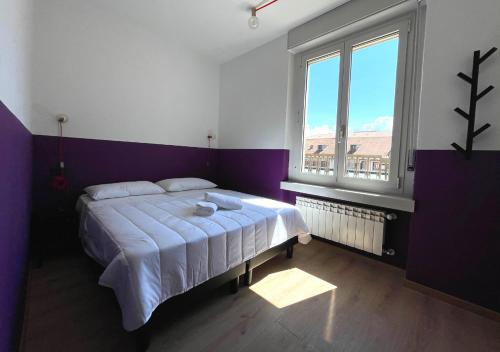 a bedroom with a bed and a large window at Hotello Trieste in Trieste