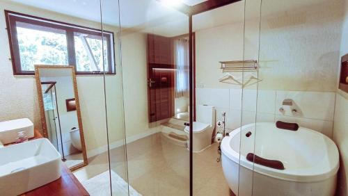 a bathroom with a toilet and a sink and a shower at Espaço Viverde Penedo in Penedo
