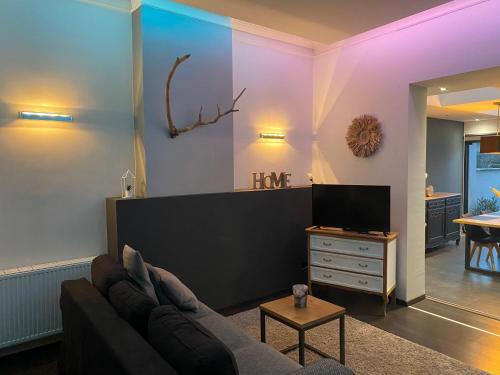 - un salon avec un canapé et une télévision dans l'établissement LA SUITE 159, à Namur
