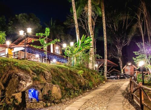 a house with lights on a hill at night at Espaço Viverde Penedo in Penedo