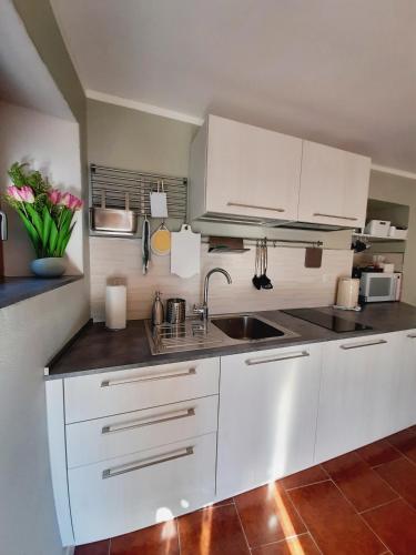 a kitchen with white cabinets and a sink at STONE in Crodo