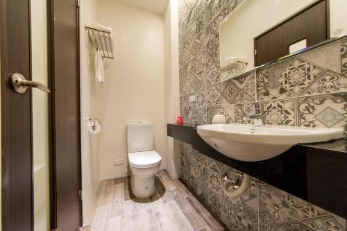 a bathroom with a white toilet and a sink at 台南安平民宿幸福拾光 in Tainan