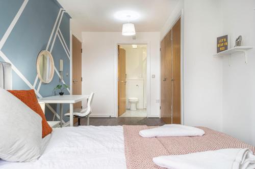 um quarto com uma cama branca e uma secretária em JKG Property Solutions Presents Cosy City Apartment em Coventry