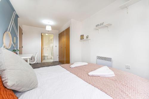 a bedroom with a bed with two towels on it at JKG Property Solutions Presents Cosy City Apartment in Coventry