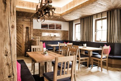 a dining room with wooden tables and chairs at Hotel Salzburgerhof in Flachau