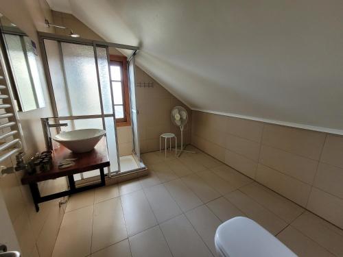 un bagno mansardato con lavandino e finestra di Hotel San Giorgio a Capitán Pastene