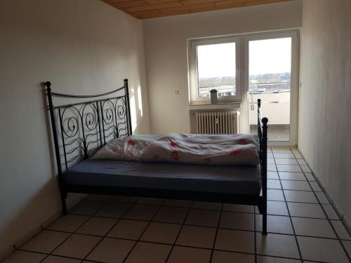 a bed sitting in a room with a window at Ferienwohnung Norf in Neuss