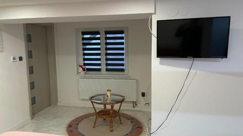 a room with a table and a tv and a chair at Penzion Hedvika in Kravaře