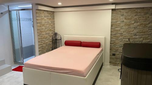 a bedroom with a bed with a red pillow on it at Penzion Hedvika in Kravaře