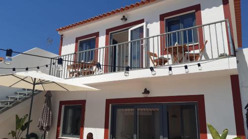 a house with a balcony with chairs on it at Cantinho de Milfontes 1 in Vila Nova de Milfontes