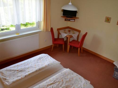 a bedroom with a bed and a table and chairs at Gästehaus Familie Grudl in Bärnkopf