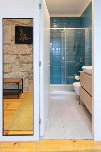 a bathroom with a shower and a toilet and a sink at HM - Porto Blue Pool Apartment in Porto