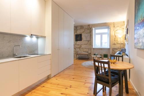 a kitchen and dining room with a table and chairs at HM - Porto Blue Pool Apartment in Porto