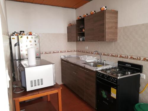 a small kitchen with a stove and a refrigerator at Hostal Colombian Gold in San Gil