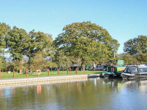 a group of boats docked on a river at The Tyre Barn in Whitchurch