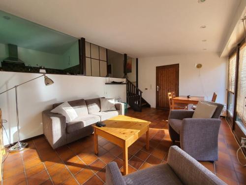 een woonkamer met een bank en een tafel bij Ferienhaus am Südhang der Bentheimer Berge nah an der Natur in Bad Bentheim