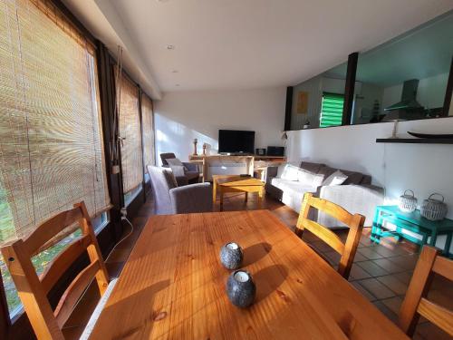 een woonkamer met een houten tafel en stoelen bij Ferienhaus am Südhang der Bentheimer Berge nah an der Natur in Bad Bentheim